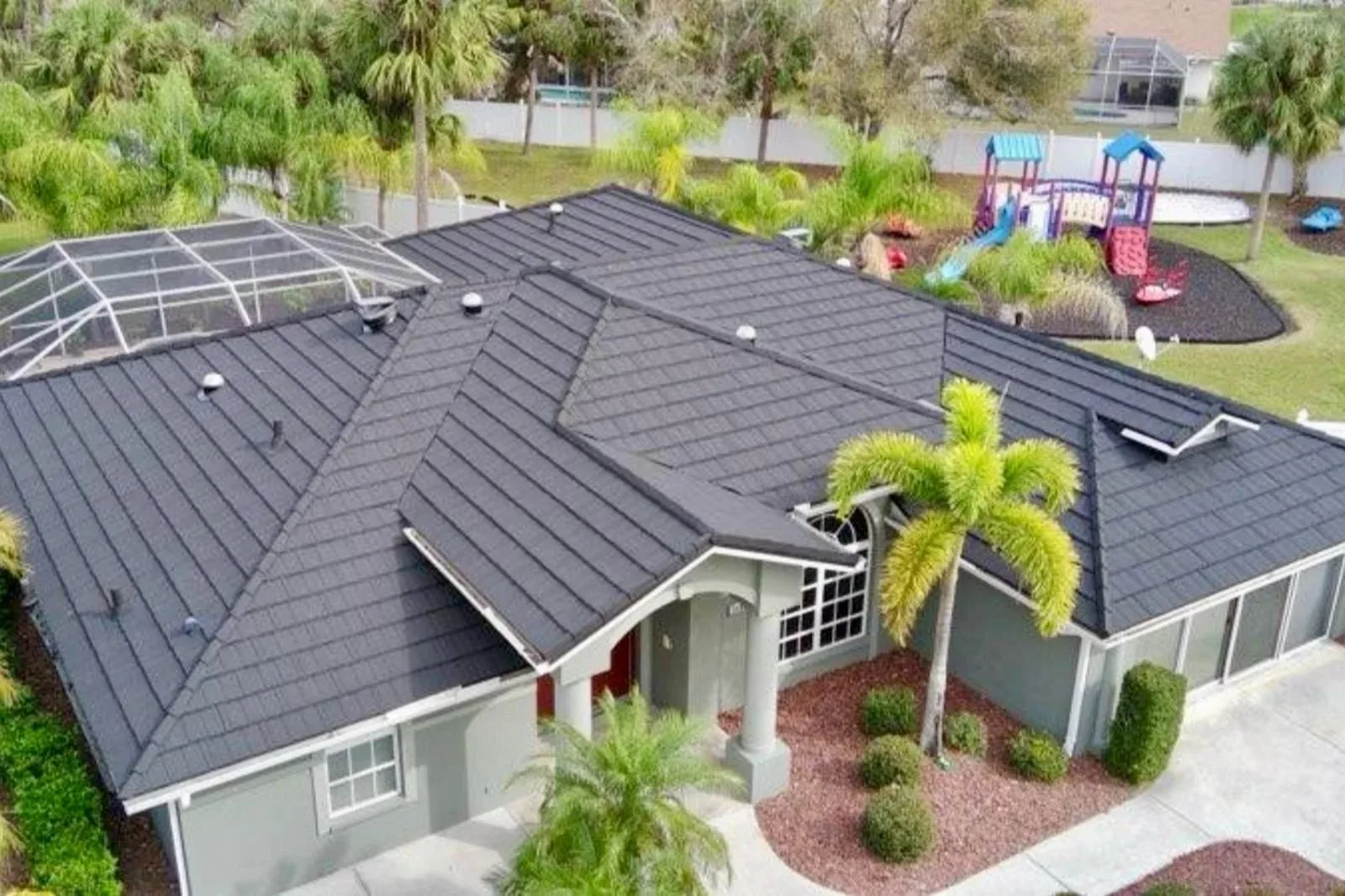 Premium weather-tight roof installation featuring dark architectural roofing on a family home in Naples by Barrier Builders.