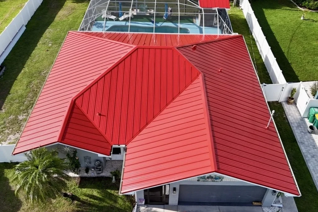 Hurricane-resistant red metal roof replacement completed for a home in Fort Myers by Barrier Builders roofing contractors.