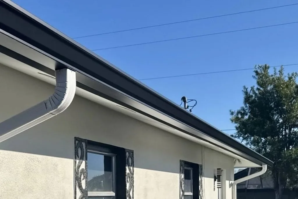 Custom seamless gutter installation providing water protection for a home's roofline in Fort Myers by Barrier Builders.