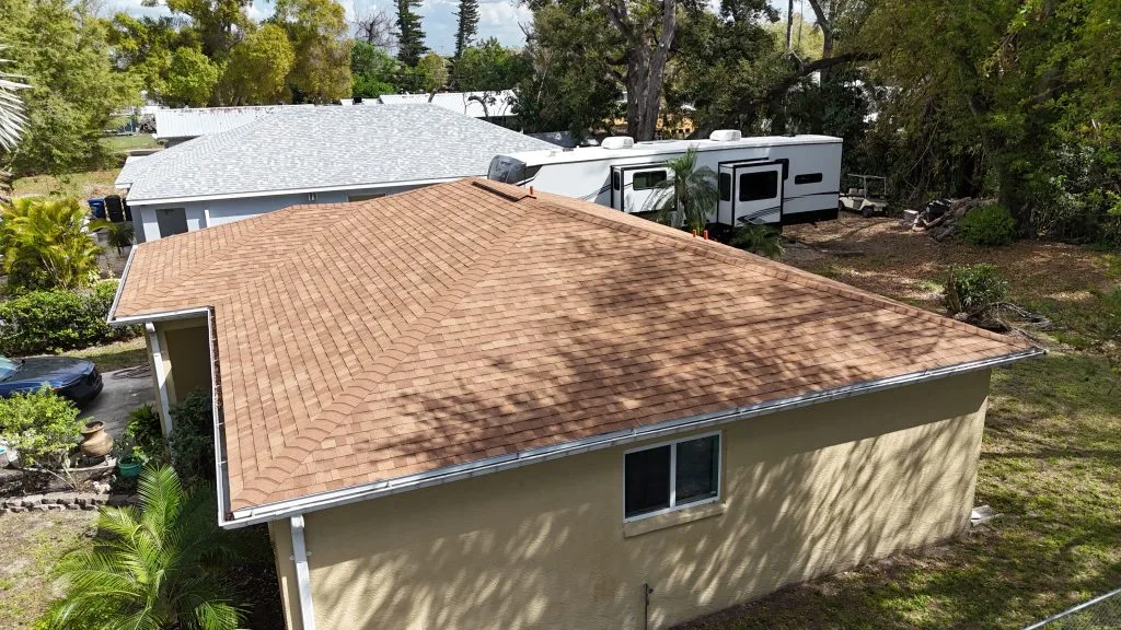 Drone shot of a durable new shingle roof protecting a family home in Sarasota, installed by Barrier Builders.